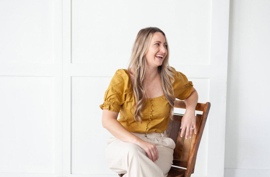 woman sitting in a wooden chair during her branding photo session in downtown Grand Rapids