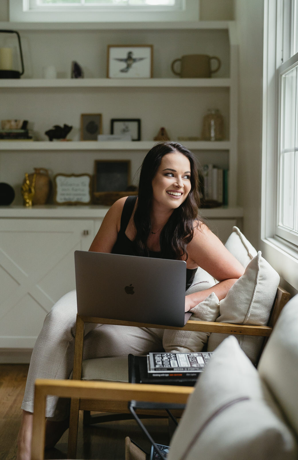 woman working on laptop while looking out the window in the living room