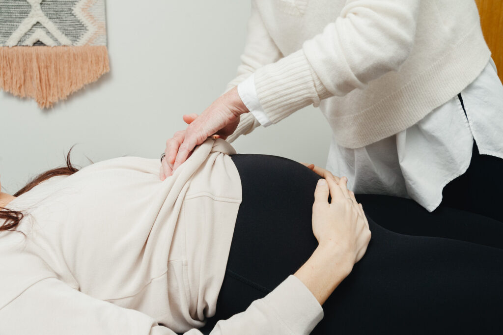 prenatal chiropractor working on the belly of a pregnant woman